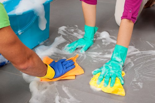 Cleaner wearing PPE while handling cleaning tasks